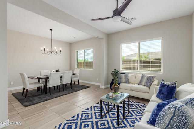 living room with tile patterned flooring and ceiling fan with notable chandelier