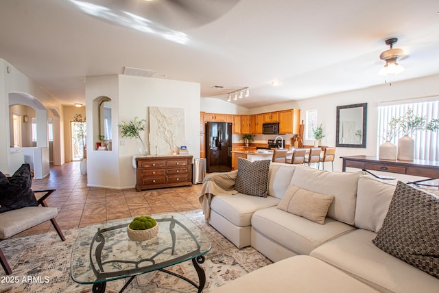 4386 E Mine Shaft Rd, San Tan Valley, AZ 85143 - living room featuring visible vents, ceiling fan, arched walkways, vaulted ceiling, and light tile patterned floors