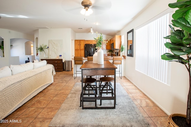 4386 E Mine Shaft Rd, San Tan Valley, AZ 85143 - dining area with vaulted ceiling, a ceiling fan, light tile patterned floors, baseboards, and arched walkways