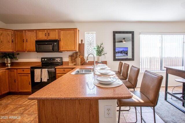 4386 E Mine Shaft Rd, San Tan Valley, AZ 85143 - kitchen with a kitchen bar, a sink, black appliances, a peninsula, and brown cabinetry