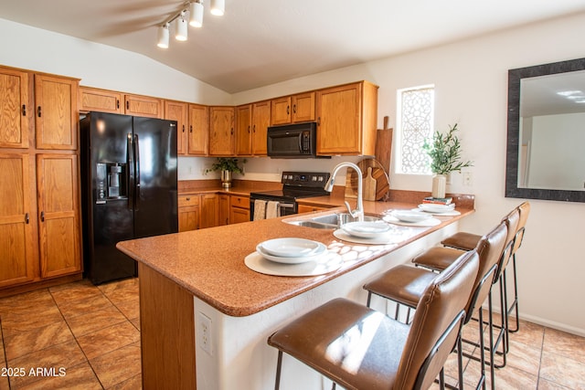 4386 E Mine Shaft Rd, San Tan Valley, AZ 85143 - kitchen with a peninsula, a sink, black appliances, vaulted ceiling, and brown cabinetry