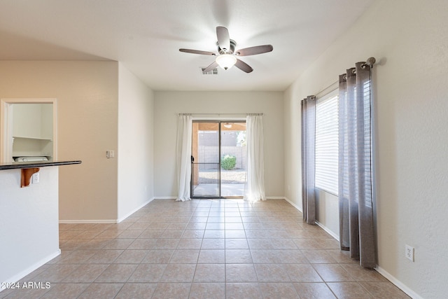 empty room featuring ceiling fan and light tile patterned floors