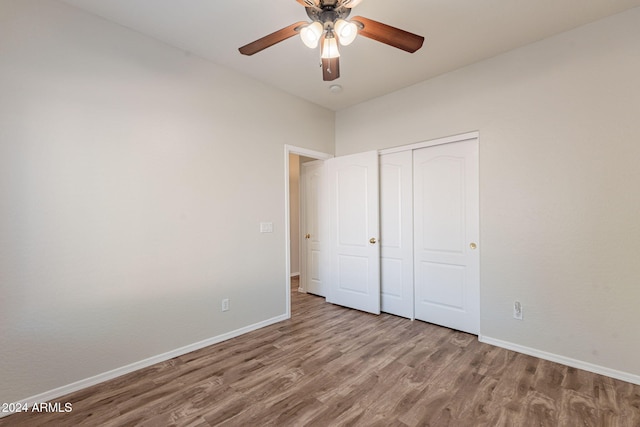 unfurnished bedroom with wood-type flooring, a closet, and ceiling fan