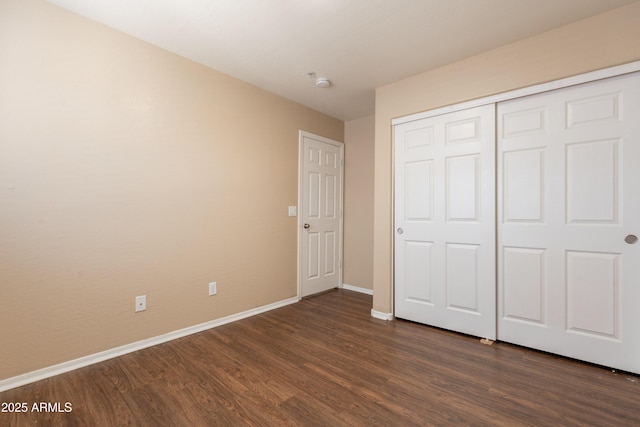 16021 N 30th St Unit 122, Phoenix, AZ 85032 - unfurnished bedroom with dark wood-type flooring, baseboards, and a closet