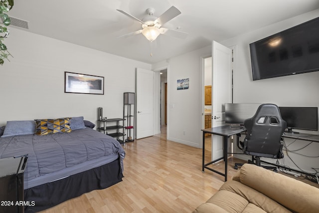 bedroom with ceiling fan, light wood-type flooring, and ensuite bath