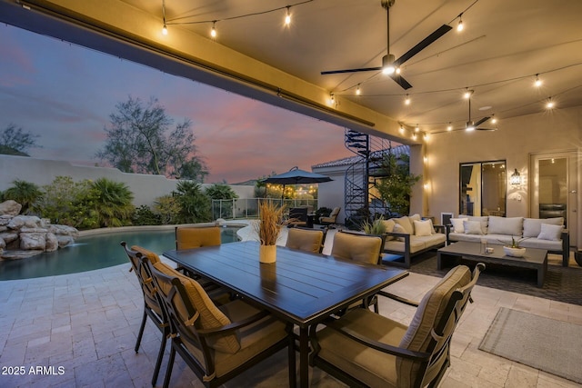 patio terrace at dusk with outdoor lounge area and a fenced in pool