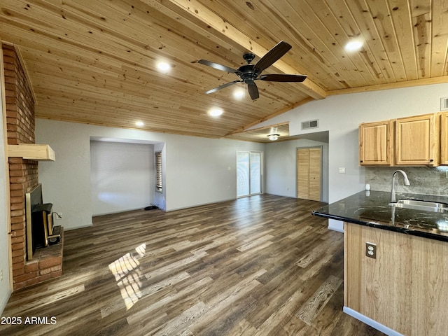 kitchen featuring sink, wood ceiling, dark wood-type flooring, vaulted ceiling with beams, and a brick fireplace