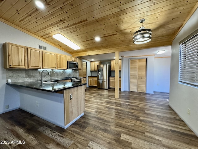 kitchen featuring pendant lighting, sink, dark wood-type flooring, stainless steel appliances, and kitchen peninsula