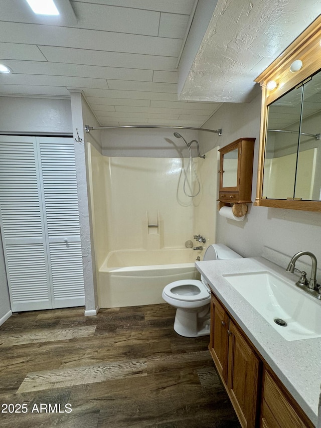 full bathroom featuring vanity, hardwood / wood-style flooring,  shower combination, and toilet