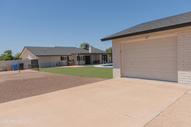 5102 W Whispering Wind Dr, Glendale, AZ 85310 - rear view of house featuring concrete driveway, brick siding, a garage, and a patio area
