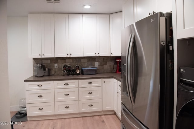 5102 W Whispering Wind Dr, Glendale, AZ 85310 - kitchen with stainless steel refrigerator with ice dispenser, washer / clothes dryer, dark countertops, white cabinetry, and recessed lighting