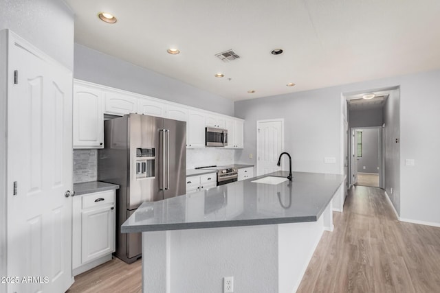 1265 S Aaron Unit 341, Mesa, AZ 85209 - kitchen with appliances with stainless steel finishes, a sink, light wood finished floors, tasteful backsplash, and white cabinetry