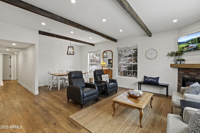 living room featuring recessed lighting, wood finished floors, baseboards, a brick fireplace, and beamed ceiling