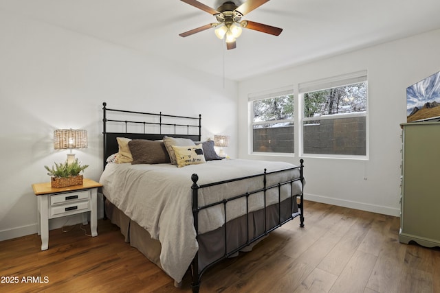 bedroom featuring a ceiling fan, baseboards, and wood finished floors