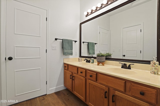 full bathroom featuring double vanity, wood finished floors, and a sink