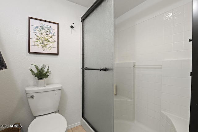 bathroom with a shower stall and toilet