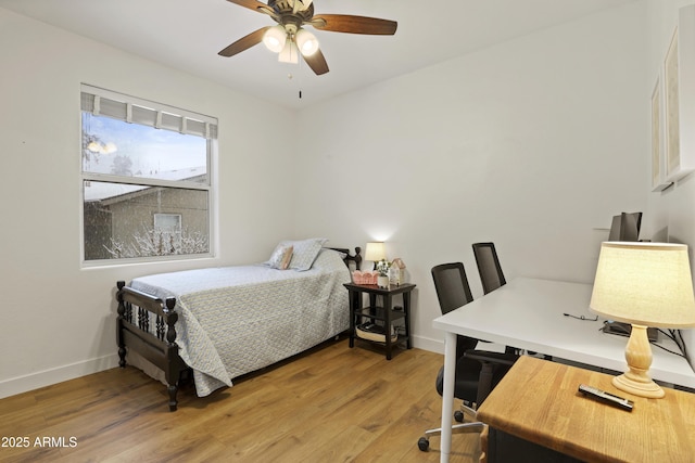 bedroom featuring a ceiling fan, baseboards, and light wood finished floors