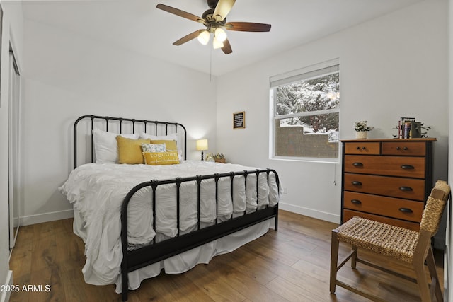 bedroom with a ceiling fan, baseboards, and wood finished floors