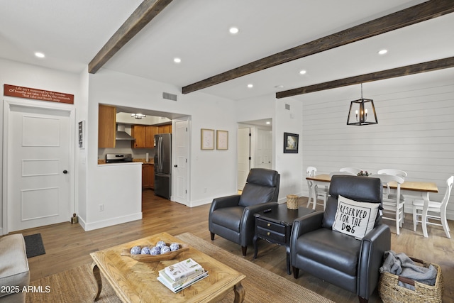 living room featuring beam ceiling, recessed lighting, visible vents, wood finished floors, and baseboards