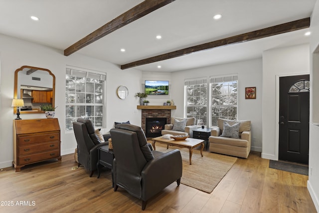 living room with baseboards, beamed ceiling, light wood-style floors, a fireplace, and recessed lighting