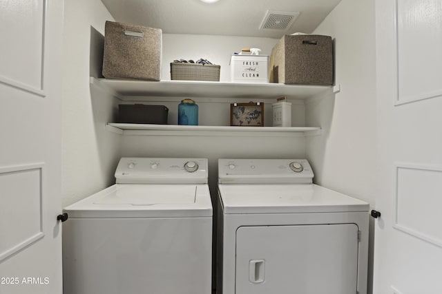 clothes washing area with laundry area, washing machine and dryer, and visible vents