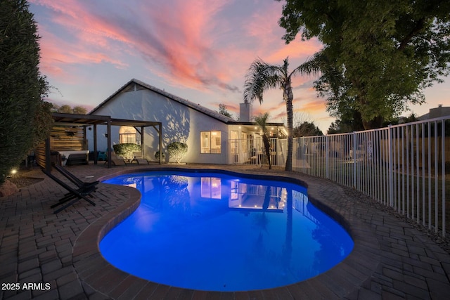 pool at dusk featuring a patio