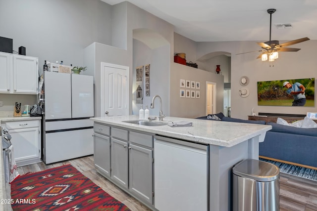 kitchen with sink, white cabinetry, a center island with sink, white refrigerator, and ceiling fan