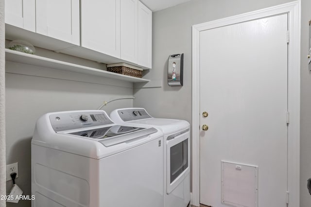 clothes washing area with washing machine and dryer and cabinets