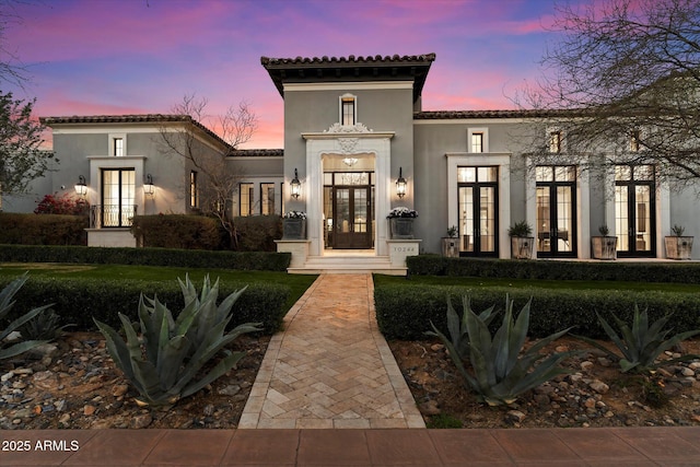 exterior space with stucco siding, a tile roof, and french doors