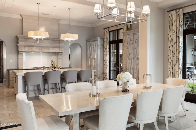 dining area with arched walkways and crown molding