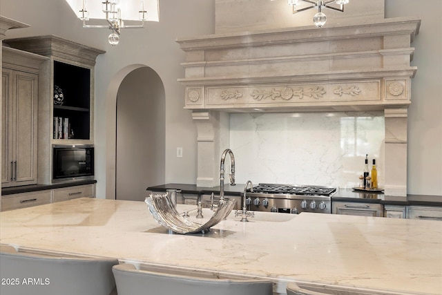 kitchen featuring tasteful backsplash, arched walkways, range, black microwave, and open shelves