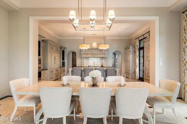 dining room with ornamental molding, arched walkways, and a chandelier