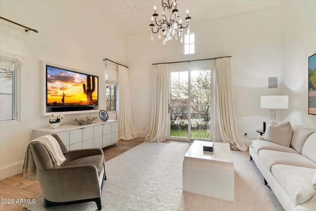 living area featuring baseboards, ornamental molding, and wood finished floors