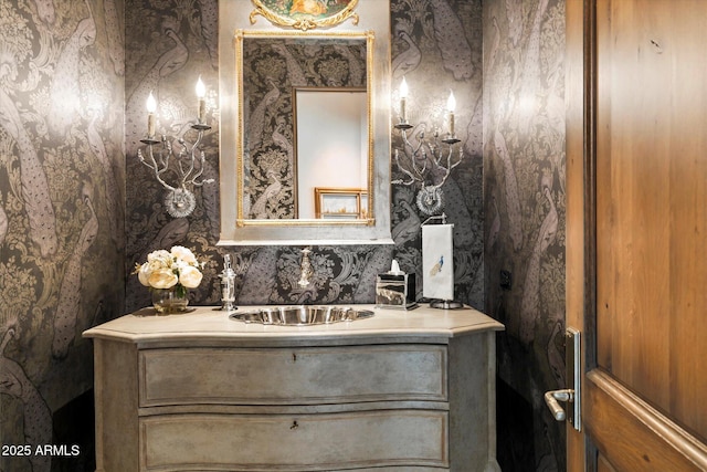 bathroom featuring vanity and wallpapered walls