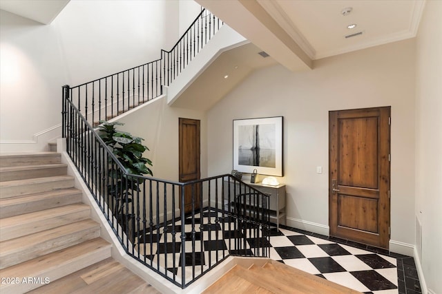 staircase featuring recessed lighting, visible vents, a high ceiling, baseboards, and tile patterned floors