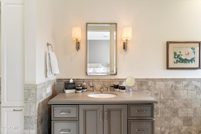 bathroom with wainscoting, tile walls, and vanity