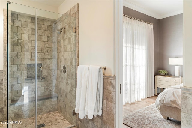 full bath with a shower stall, ornamental molding, and wood finished floors