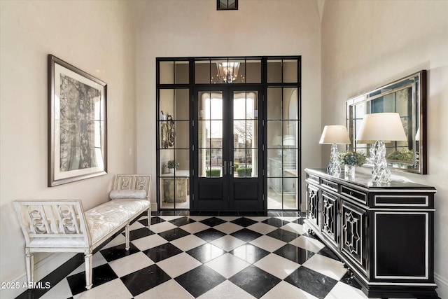 entrance foyer with french doors, a high ceiling, and tile patterned floors