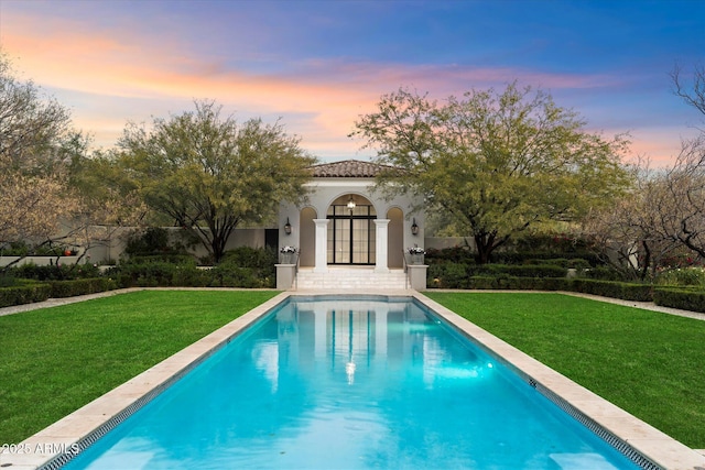 pool featuring french doors and a yard