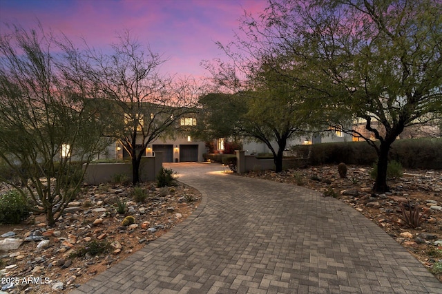 view of front facade with decorative driveway and stucco siding