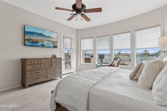 bedroom with ceiling fan, multiple windows, and access to outside