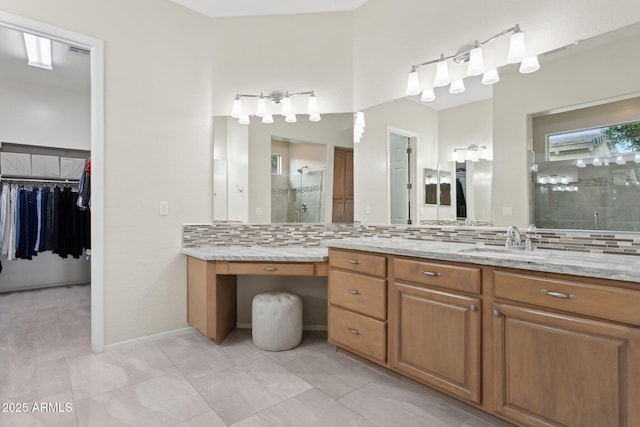 bathroom with tasteful backsplash, vanity, tile patterned floors, and walk in shower