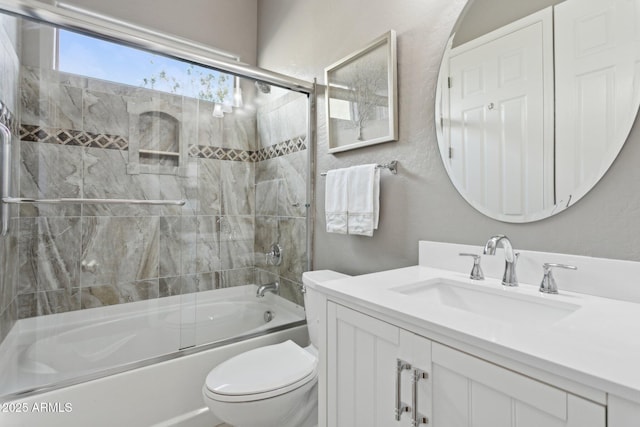 full bathroom featuring vanity, combined bath / shower with glass door, and toilet