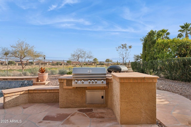 view of patio with area for grilling and a grill