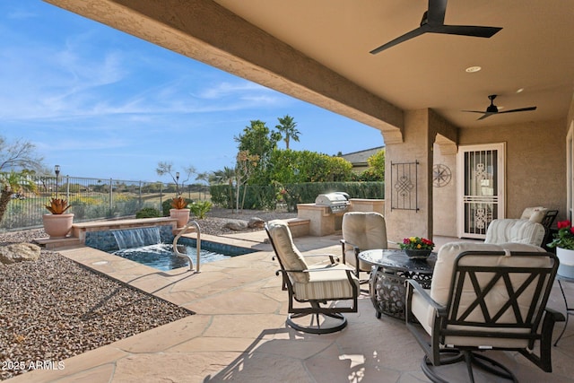 view of patio featuring pool water feature, ceiling fan, a fenced in pool, and exterior kitchen