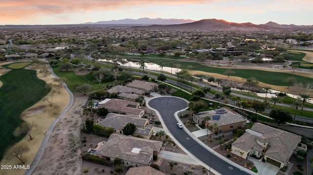 aerial view at dusk featuring a water and mountain view