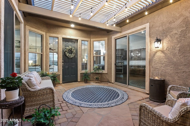 view of exterior entry with a pergola and a patio