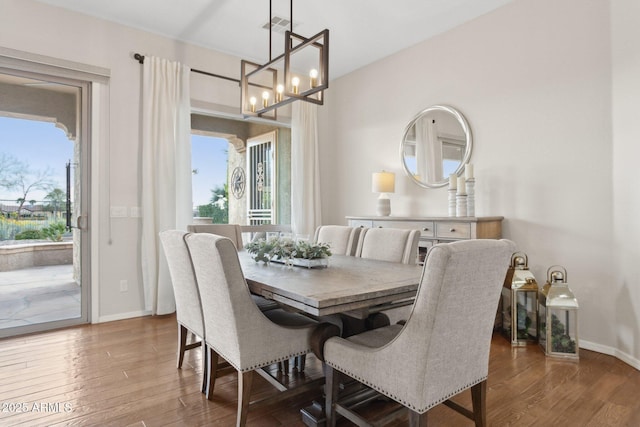 dining space with an inviting chandelier, hardwood / wood-style floors, and a wealth of natural light