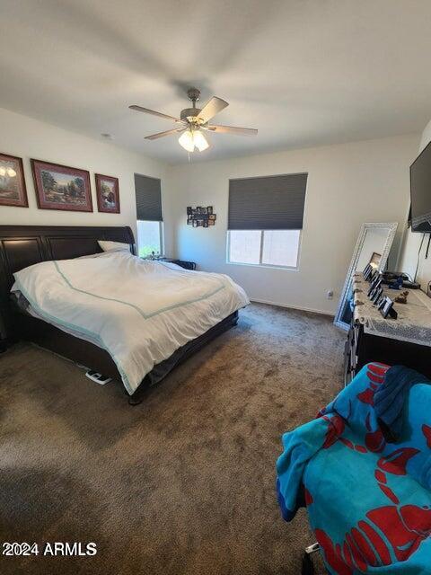 bedroom featuring dark carpet and ceiling fan