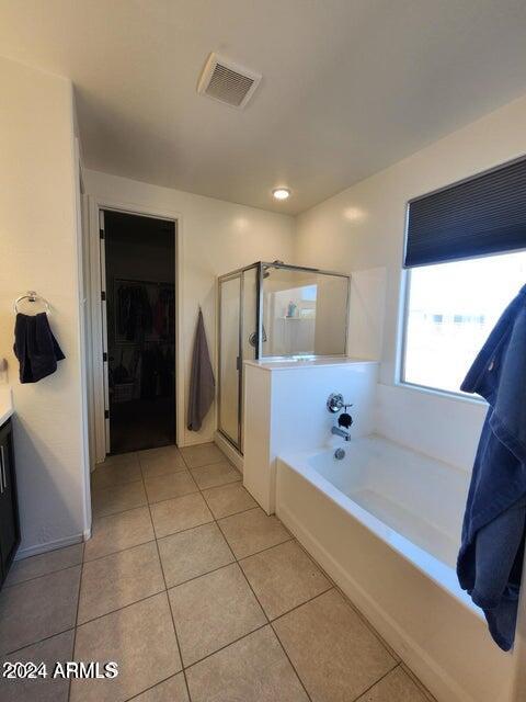 bathroom with tile patterned flooring, vanity, and separate shower and tub